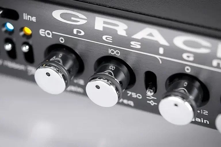 Close-up detail of silver control knobs and switches on a Grace Design m103 channel strip faceplate.