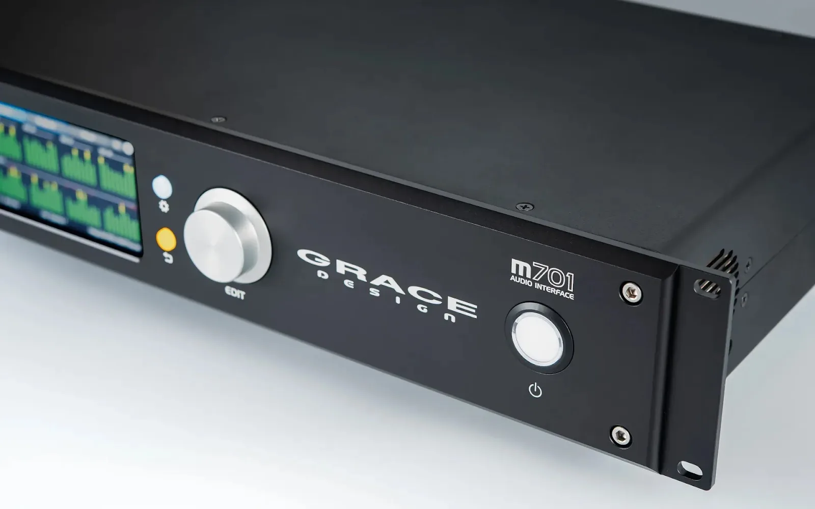 Angled close-up of the Grace Design m701 audio interface front panel, featuring a power button and rotary dial.