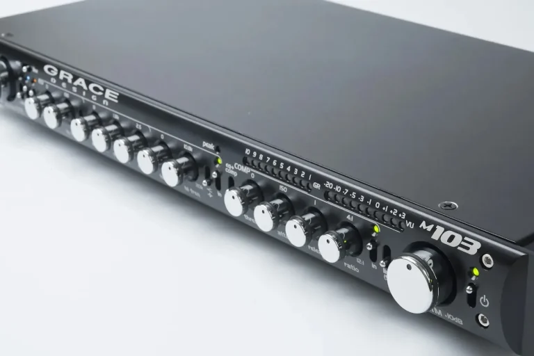 Grace Design m1033 channel strip unit featuring precision control knobs, LED meters, and a black faceplate.