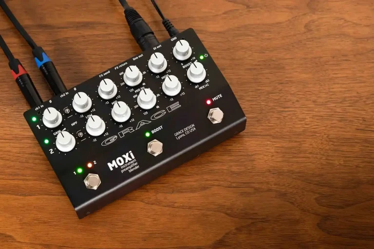Grace Design MOXi dual-channel instrument preamp pedal with knobs, footswitches, and audio cables on wood.